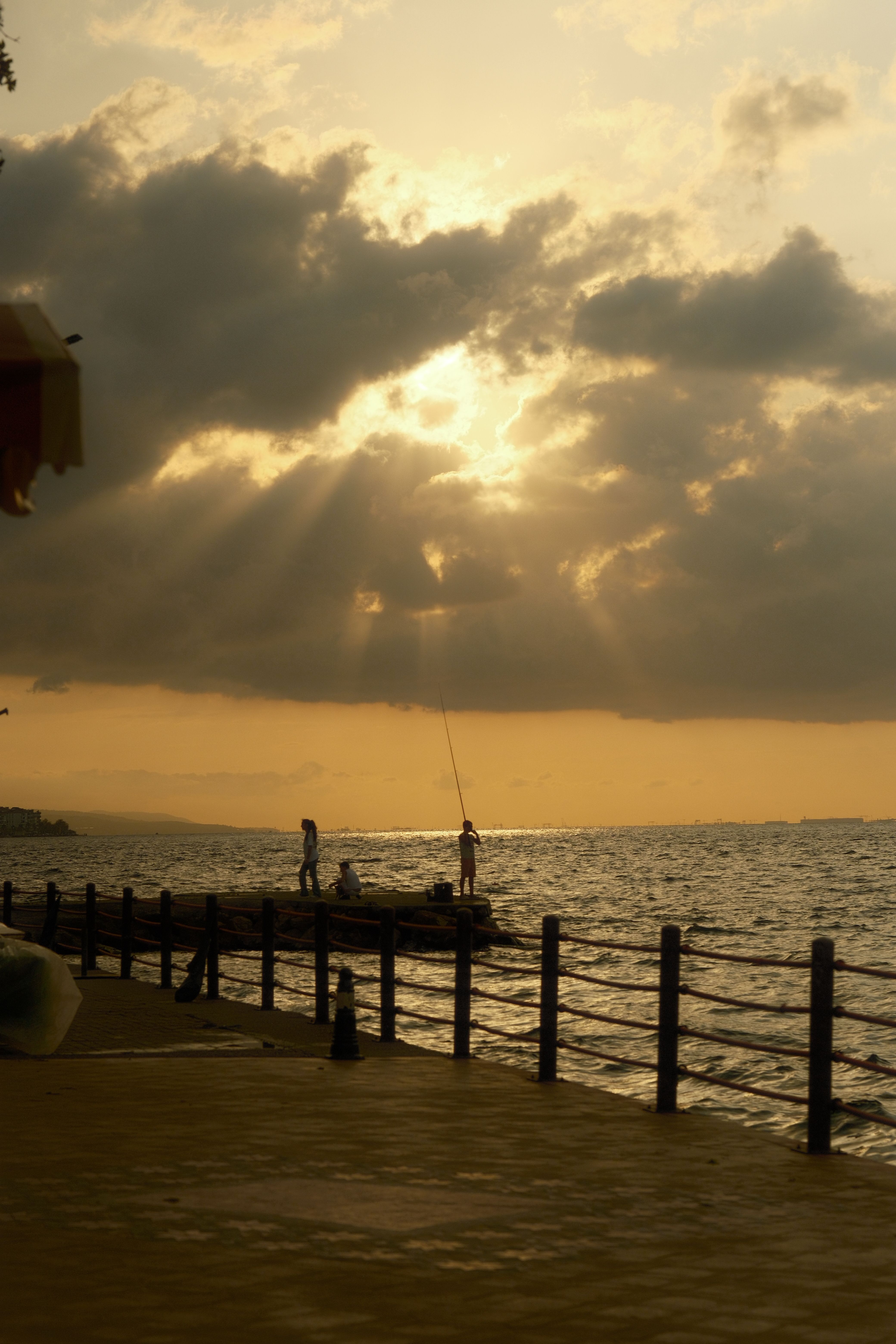 Golden Sunset Over Ocean with Pier and Fishermen · Free Stock Photo