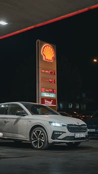 A sleek Skoda sedan parked at a Shell gas station during nighttime.