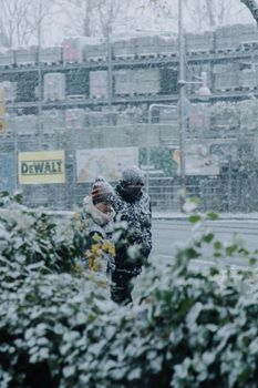 Two people walk through a snowy street in Bretten, Germany, during a winter snowfall.