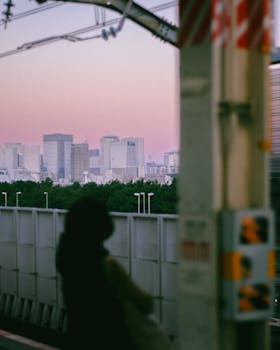 A soft light sunrise over Tokyo from a station, blending cityscape and serenity.