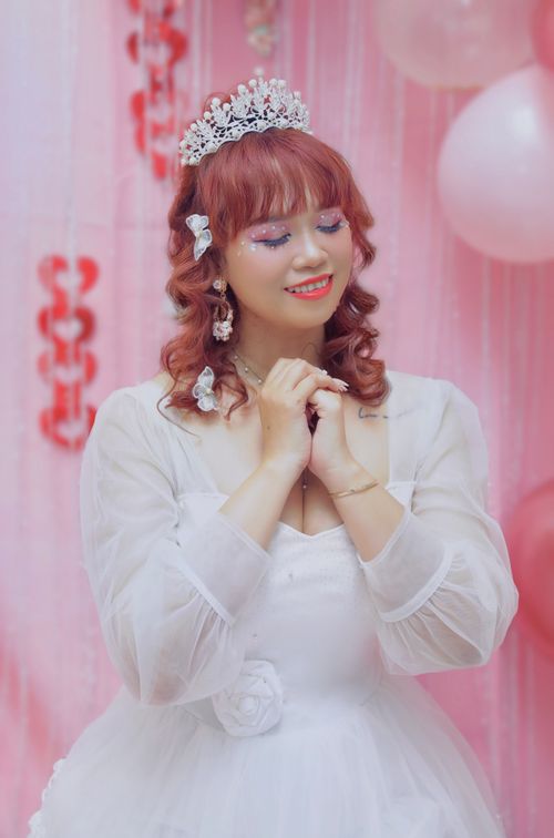 Free Young woman in a bridal dress with tiara and pink decorations in a dreamy setting. Stock Photo