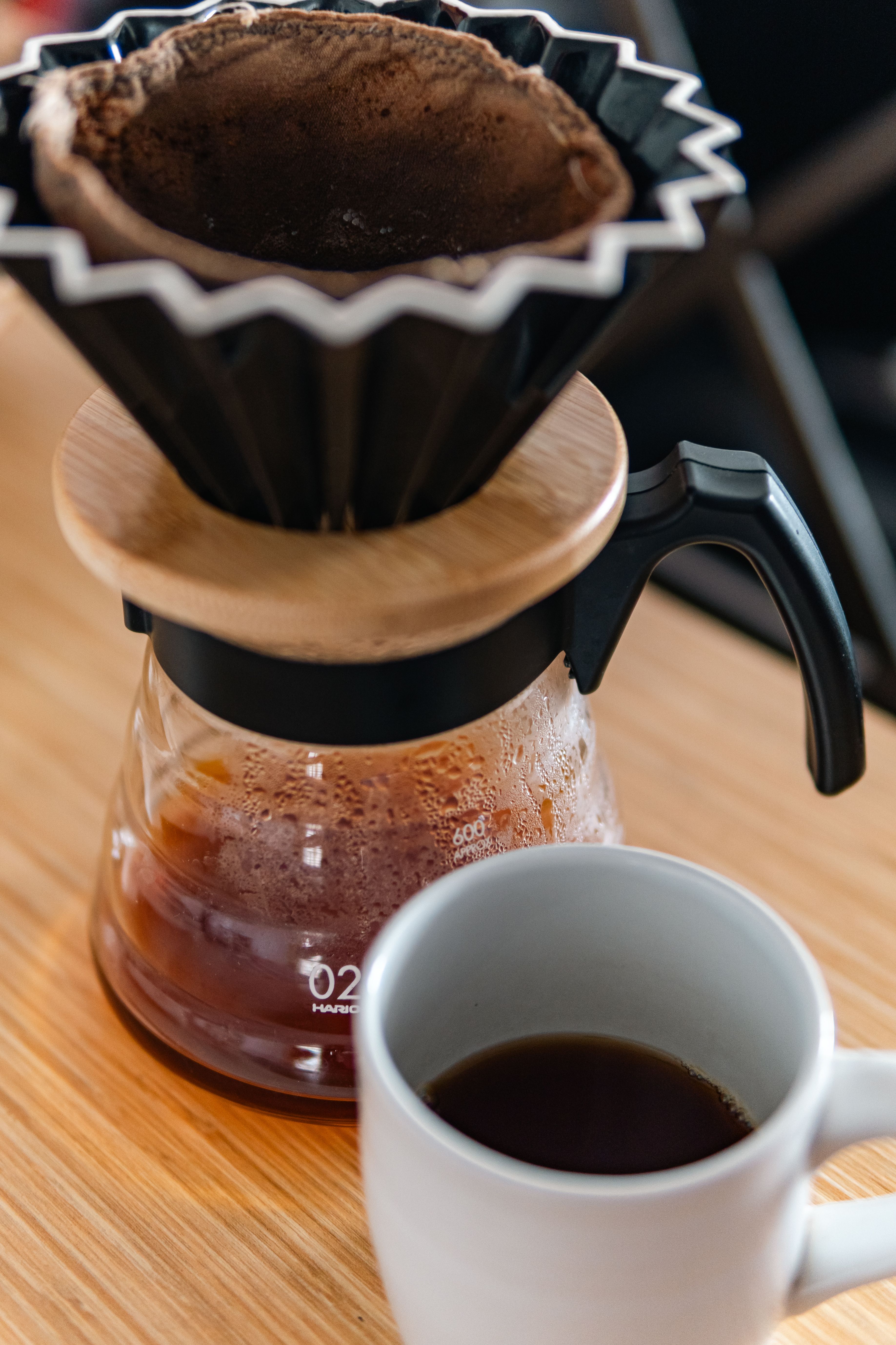 Gratis Una tazza fumante di caffè filtrato accanto a una macchina per il caffè con filtro in tessuto. Foto a disposizione