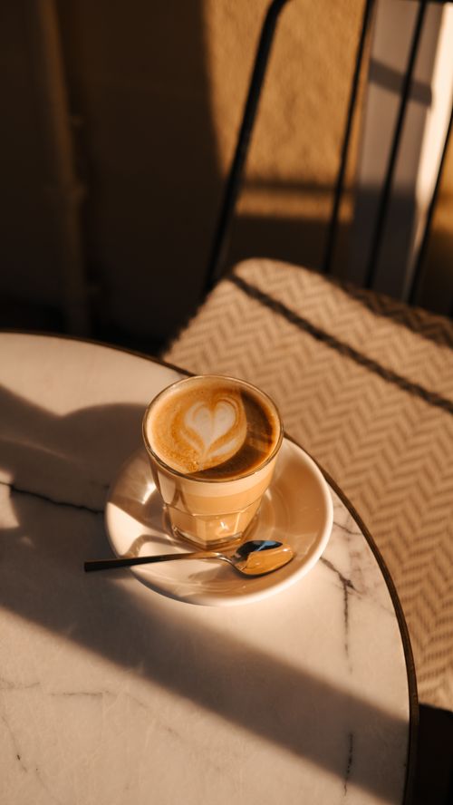 Free Enjoy a latte with heart-shaped art on a sunlit Istanbul cafe table. Stock Photo