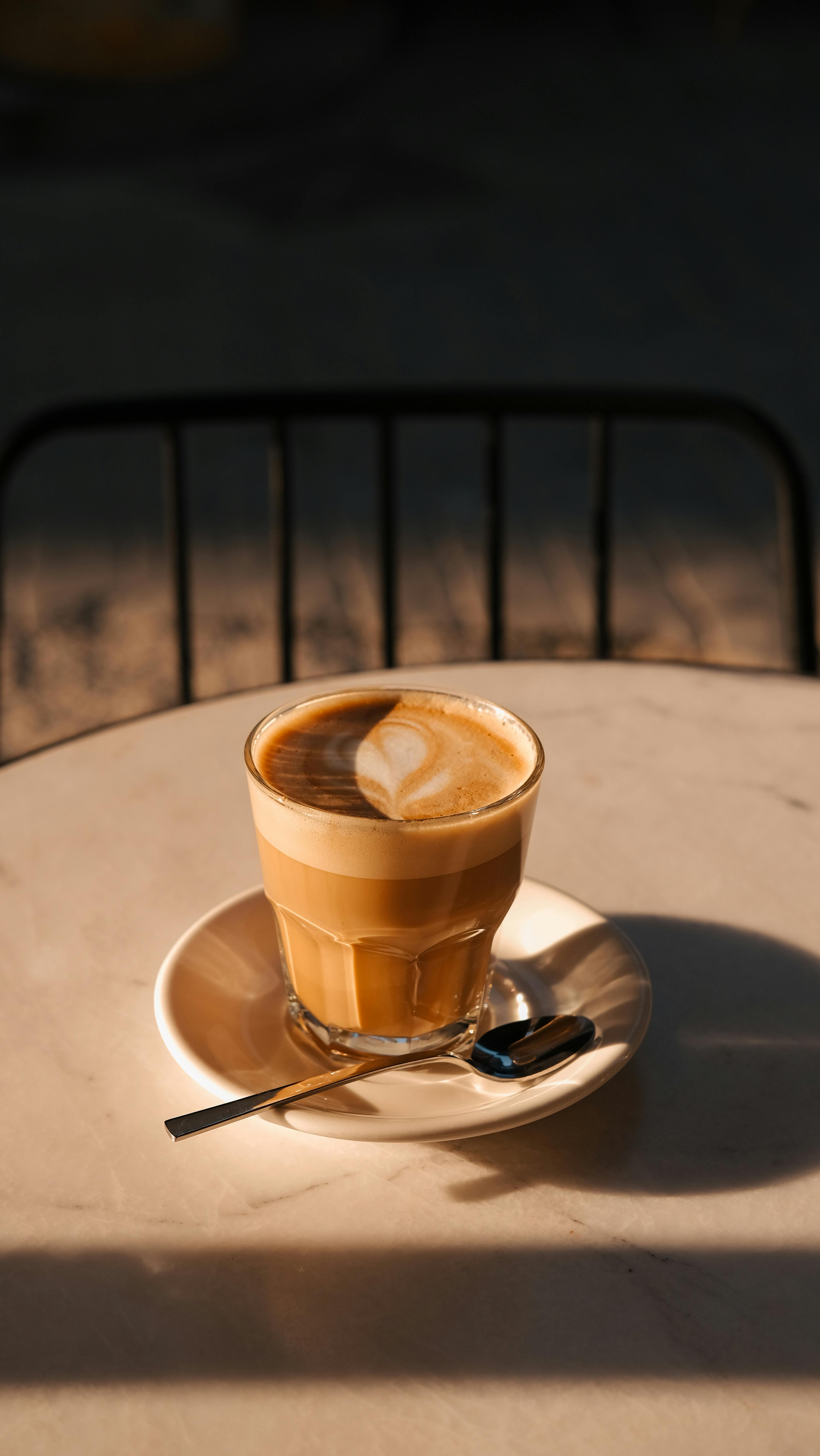 A warm, inviting café latte sits on a sunlit table, perfect for coffee lovers.