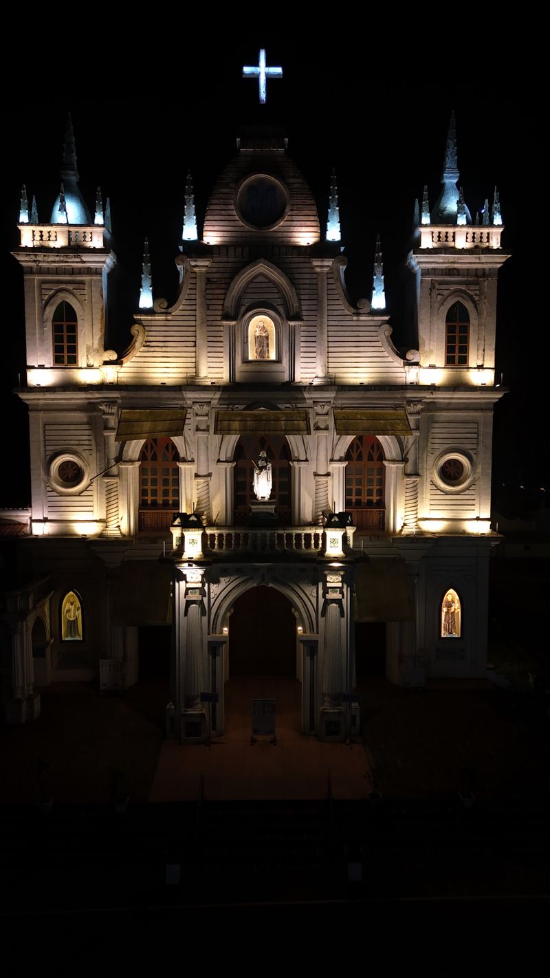 Illuminated church facade glowing at night during a festa celebration
