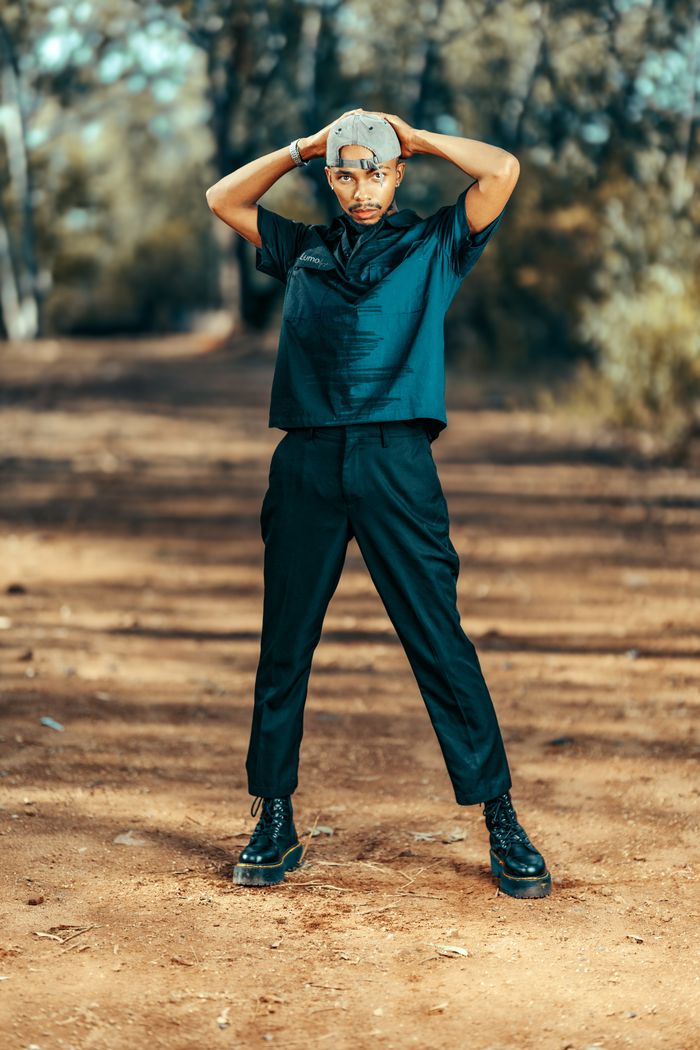Man in stylish attire posing outdoors, photo by Lucretius Mooka on Pexels