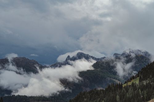 Free A breathtaking view of misty mountains and dense forests under dramatic skies. Stock Photo