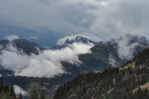 Free Stunning view of mountains shrouded in mist and clouds, perfect for nature themes. Stock Photo