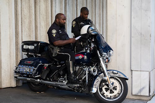 Stojący Policjant Obok Innego Mężczyzny Siedzącego Na Motocyklu Policyjnym