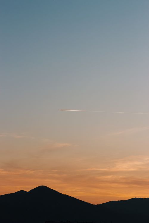 Free A serene sunset with a mountain silhouette and colorful sky hues. Stock Photo