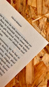 Close-up of Turkish text on a book page placed on a wooden surface. — photo by Nur Nur