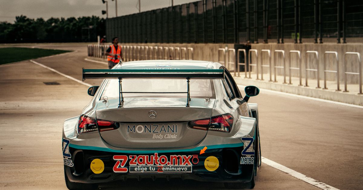 Rear View of Race Car on Track in Cloudy Weather · Free Stock Photo