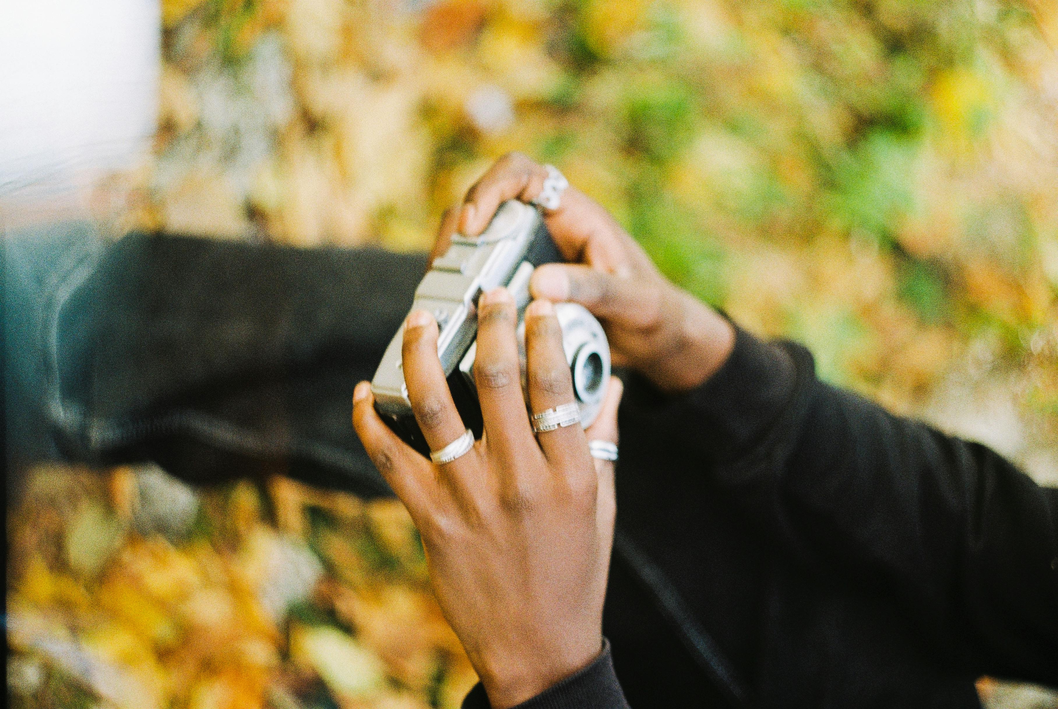 close up of hands holding vintage camera in autumn