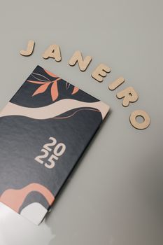 A stylish 2025 planner with the word 'Janeiro' constructed from wooden letters.