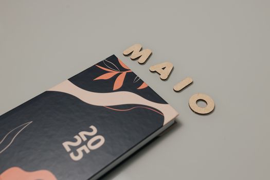 Stylish 2025 planner with 'MAIO' letters on a minimalist desk.