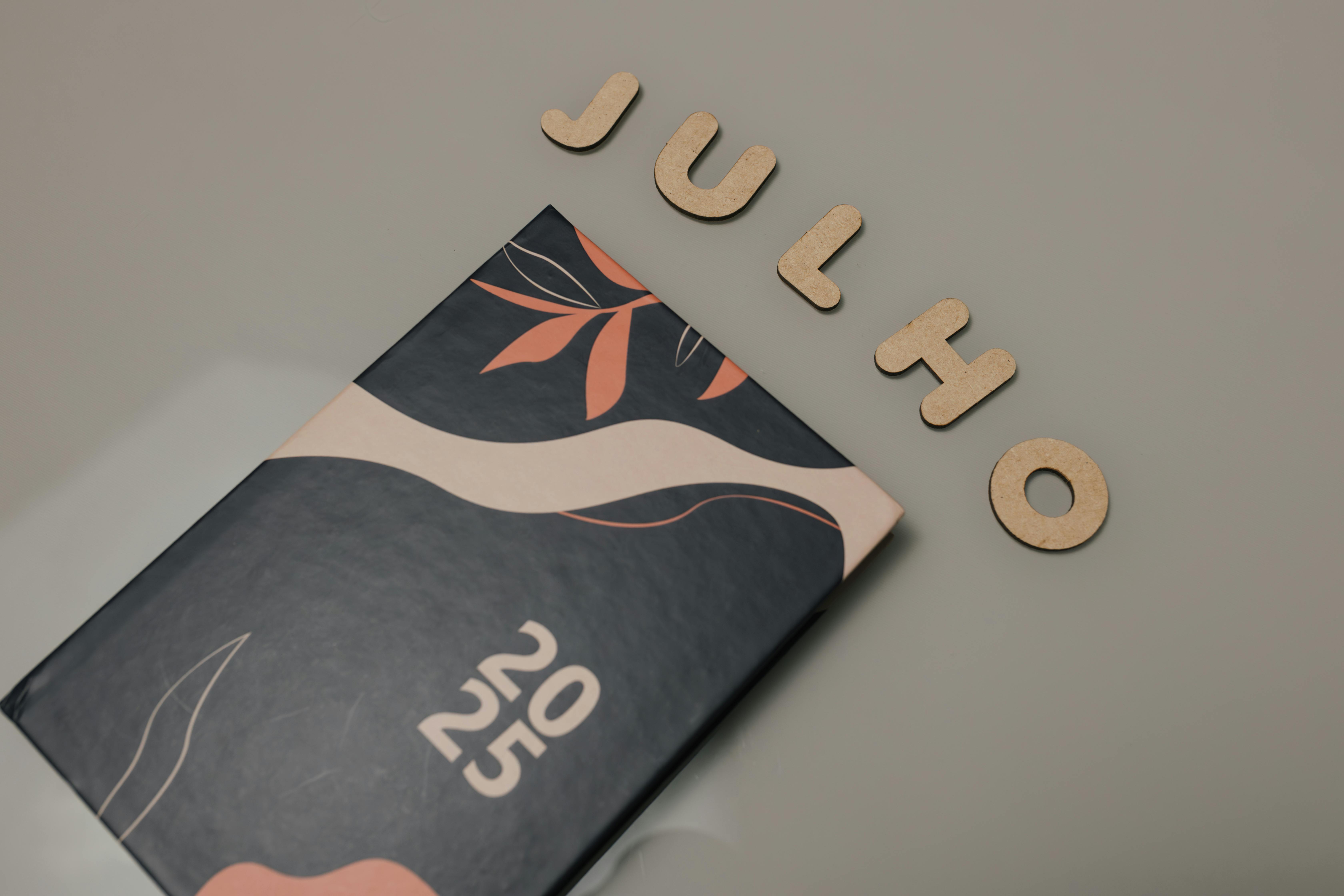 grátis Vista superior da agenda 2025 com letras Julio em fundo neutro. Foto profissional