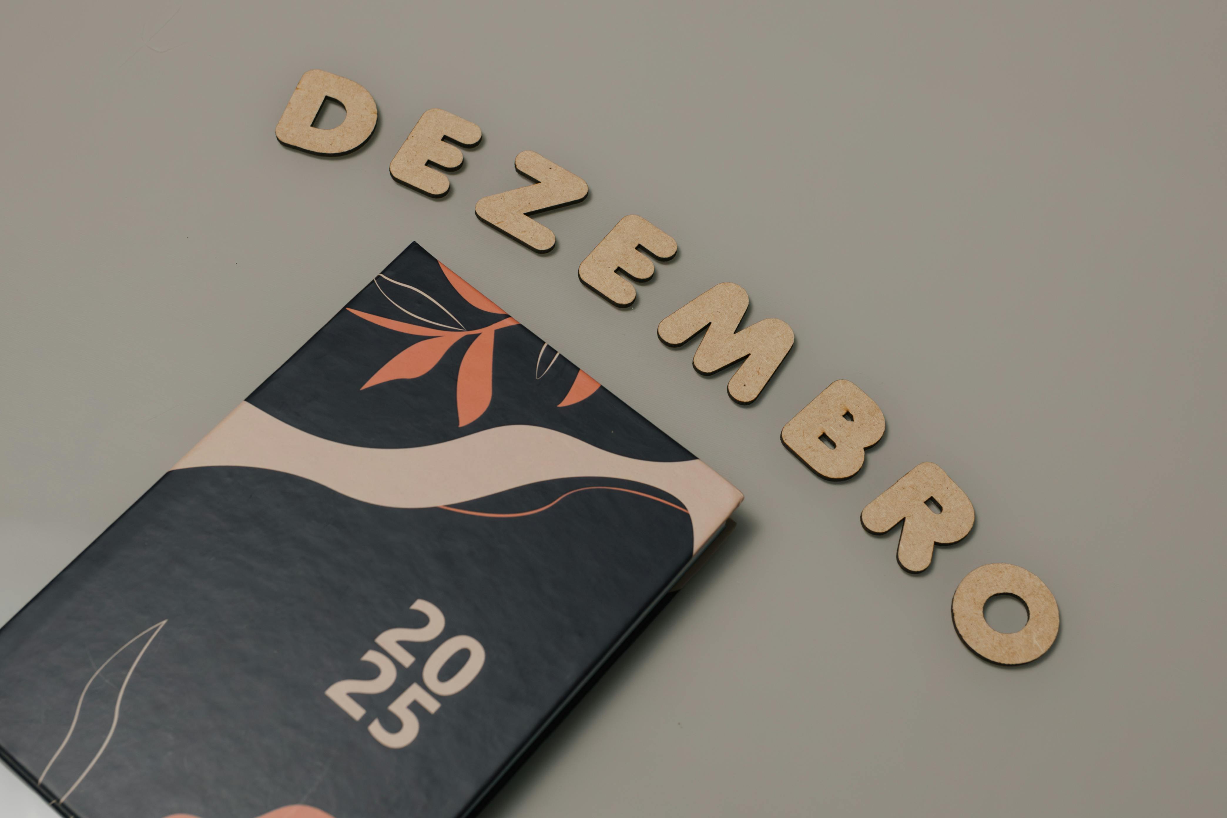 Stylish 2025 planner with 'Dezembro' wooden letters on a neutral background.