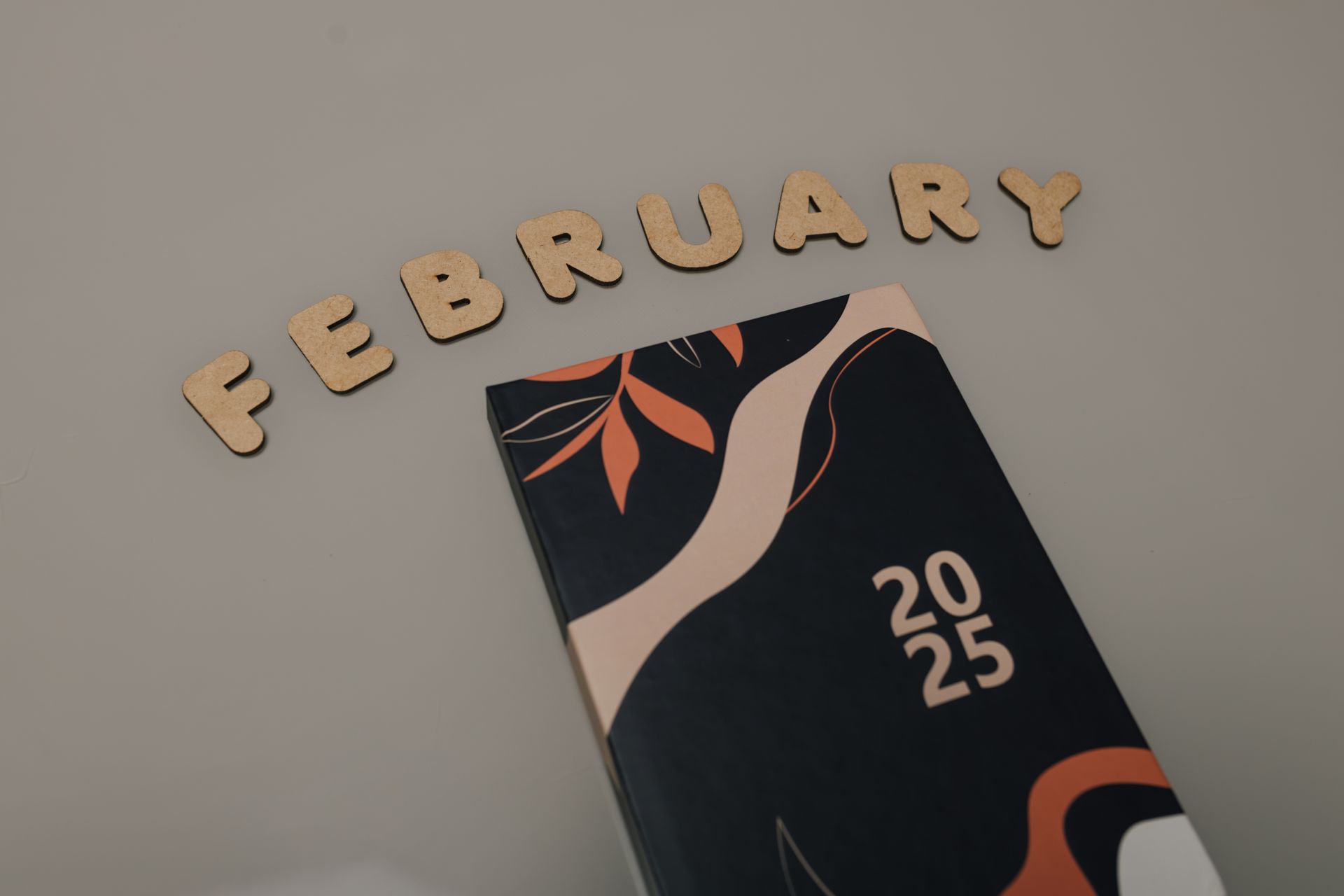 Artistic 2025 planner on a minimalist background with the word "February" in decorative letters.