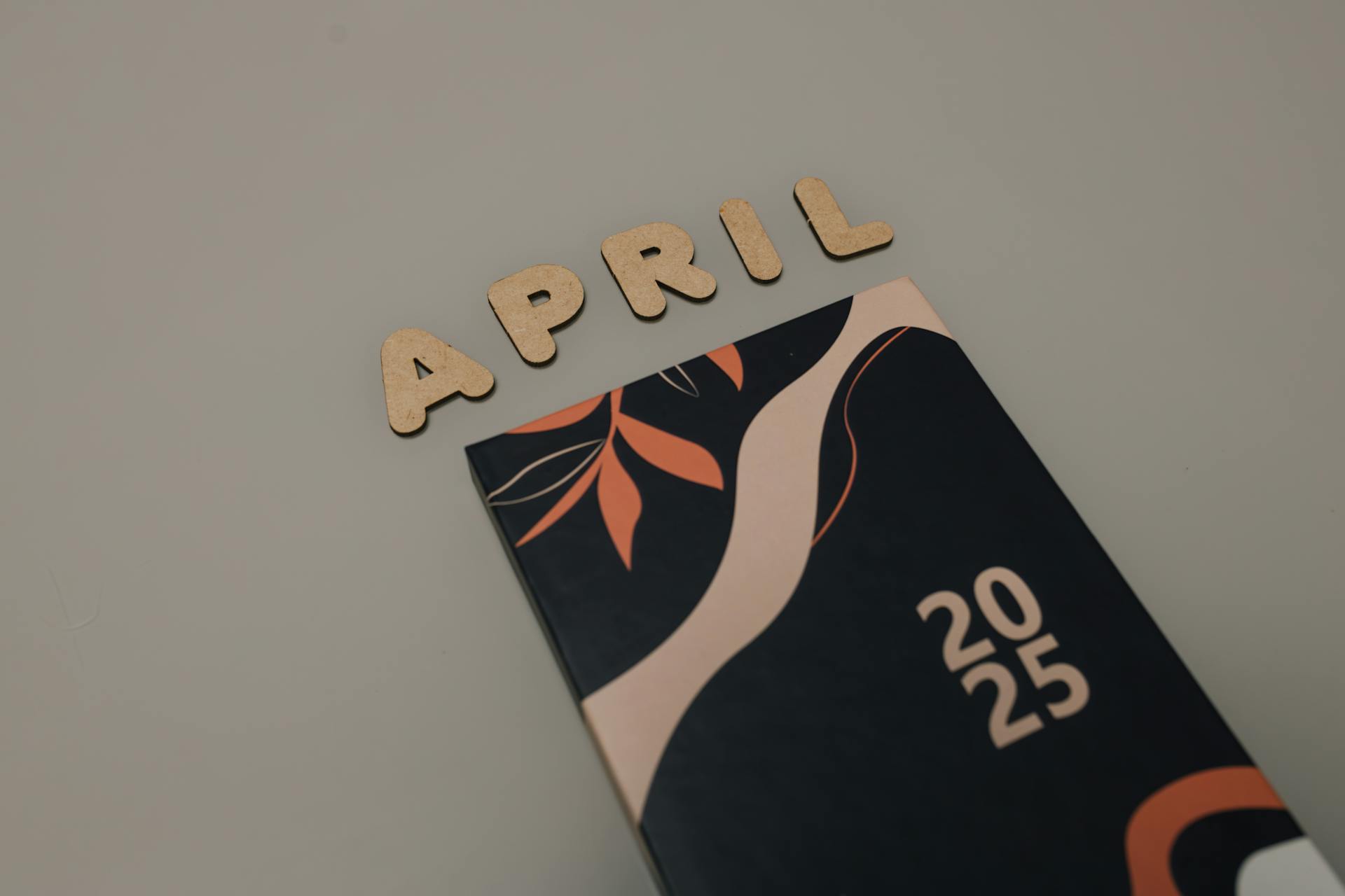 Flat lay of April 2025 calendar planner with stylish design. Perfect for organizing your schedule.