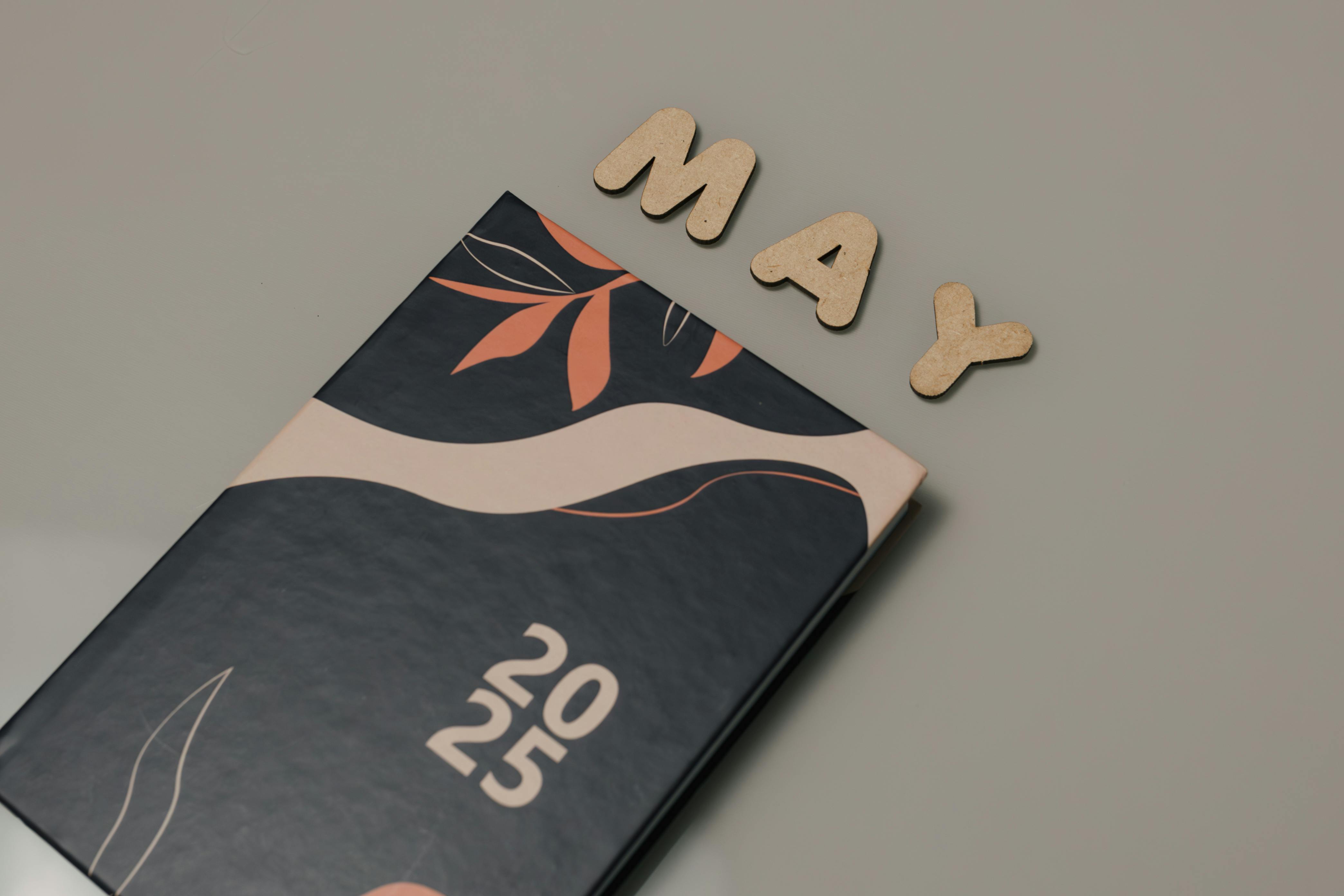 grátis Um planejador moderno e estiloso para 2025 ao lado de letras de madeira soletrando 'MAY'. Perfeito para organização. Foto profissional