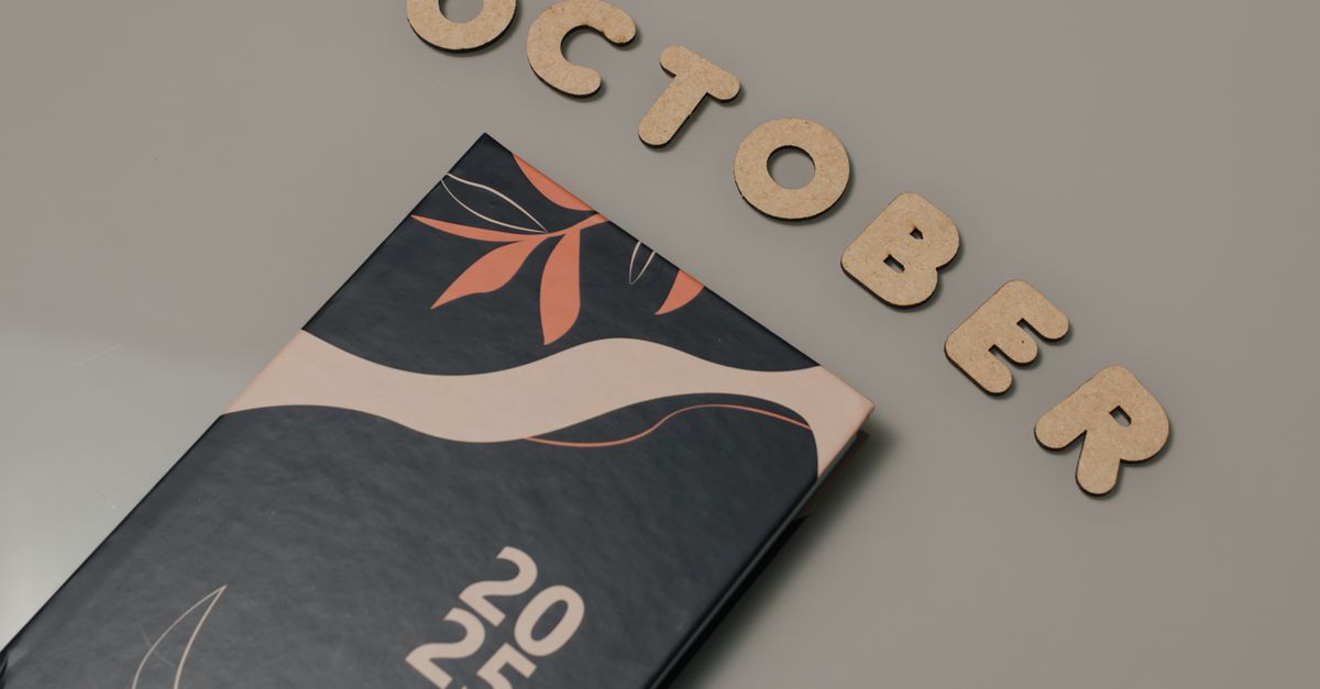 A sleek planner with October letters and 2025 date, set on a neutral surface.