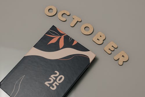 Free A sleek planner with October letters and 2025 date, set on a neutral surface. Stock Photo