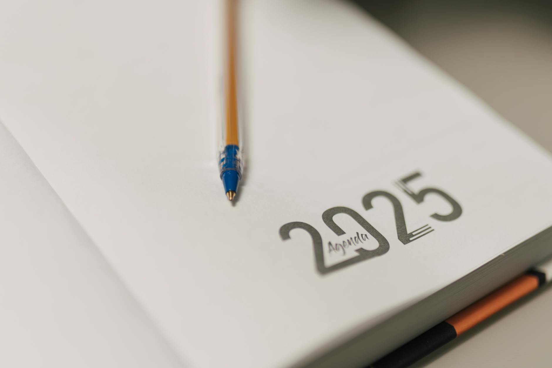 Closeup of a 2025 planner with a pencil, symbolizing planning and organization.