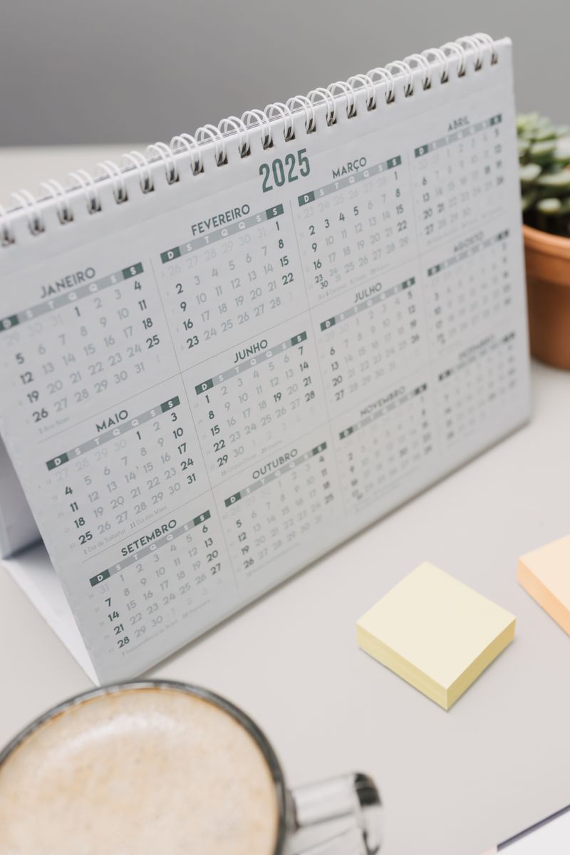 Desk calendar with coffee and sticky notes used to plan a month of social posts