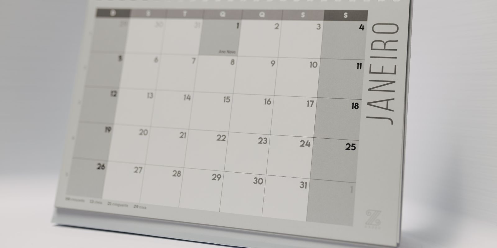 A spiral-bound desk calendar showing a monthly grid
