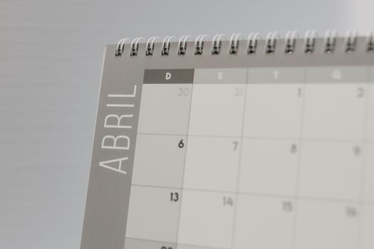 Spiral-bound calendar open to April in Spanish, focused on dates and design.