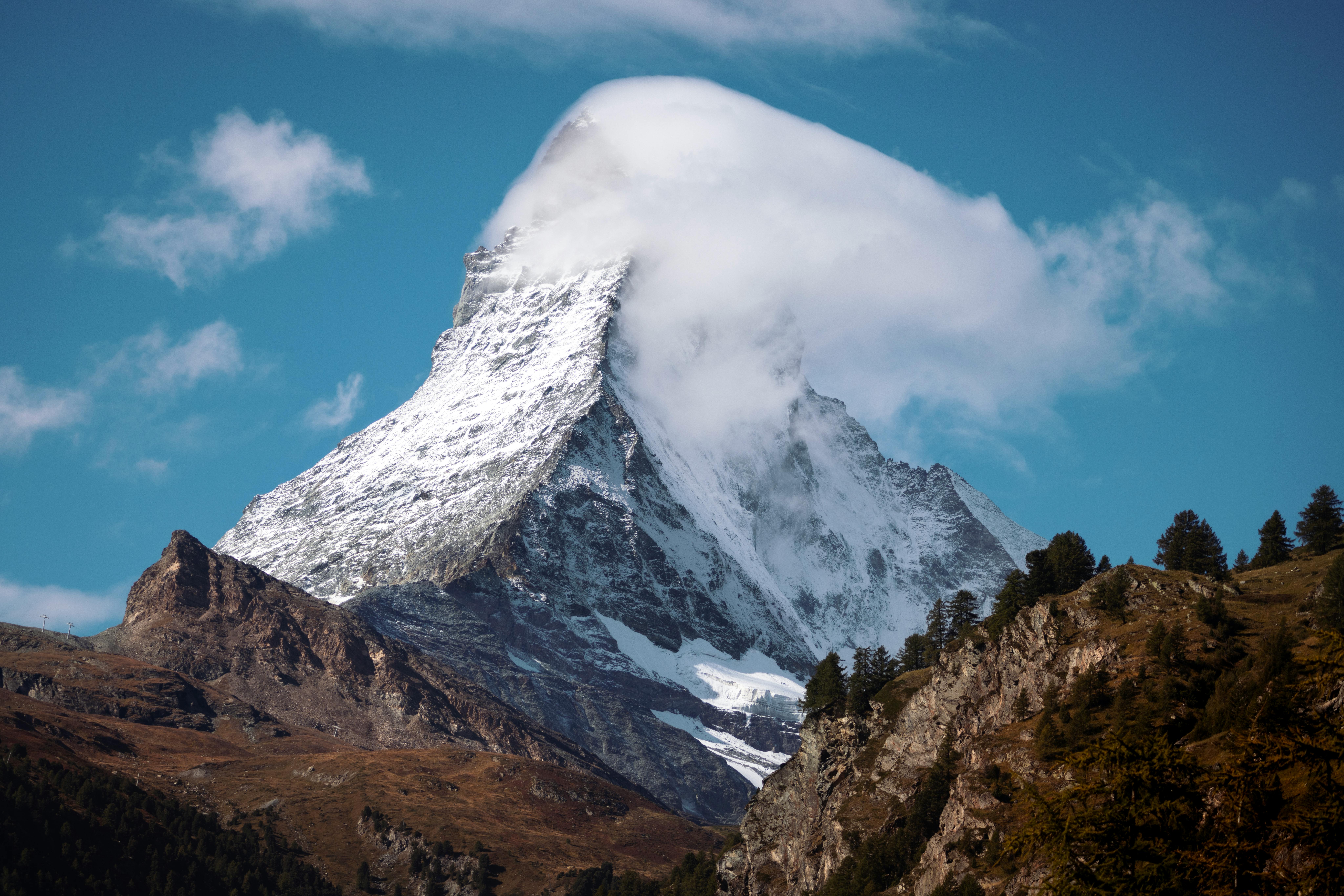 Beautiful view of the iconic snowy Matterhorn mountain peak, surrounded by clear blue sky in Switzerland.