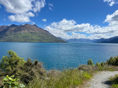 Free Beautiful summer landscape featuring a lake and mountains under a bright blue sky. Stock Photo