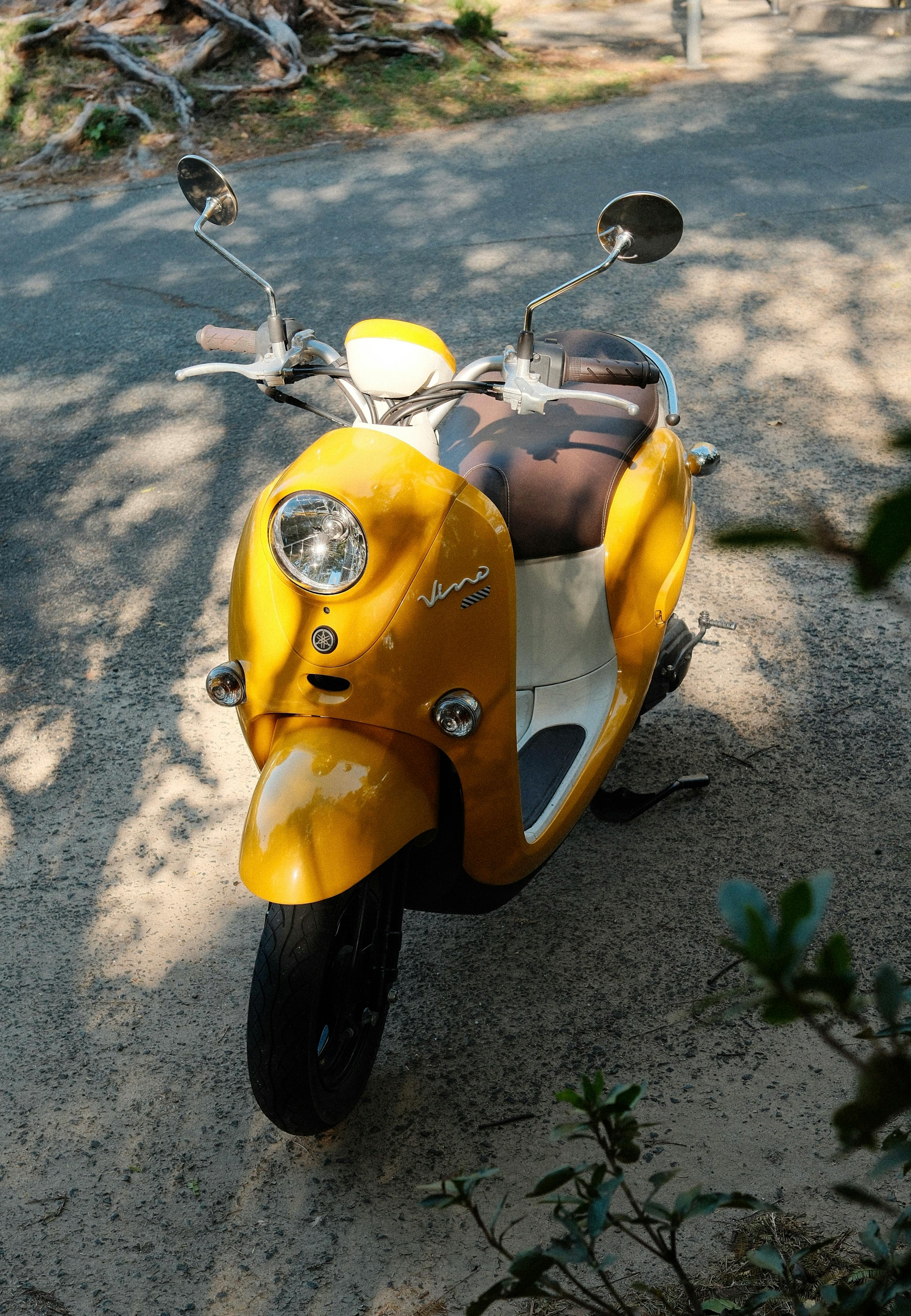 https://images.pexels.com/photos/29511296/pexels-photo-29511296/free-photo-of-yellow-scooter-parked-on-sunlit-path.jpeg?auto=compress&cs=tinysrgb&w=1260&h=750&dpr=2