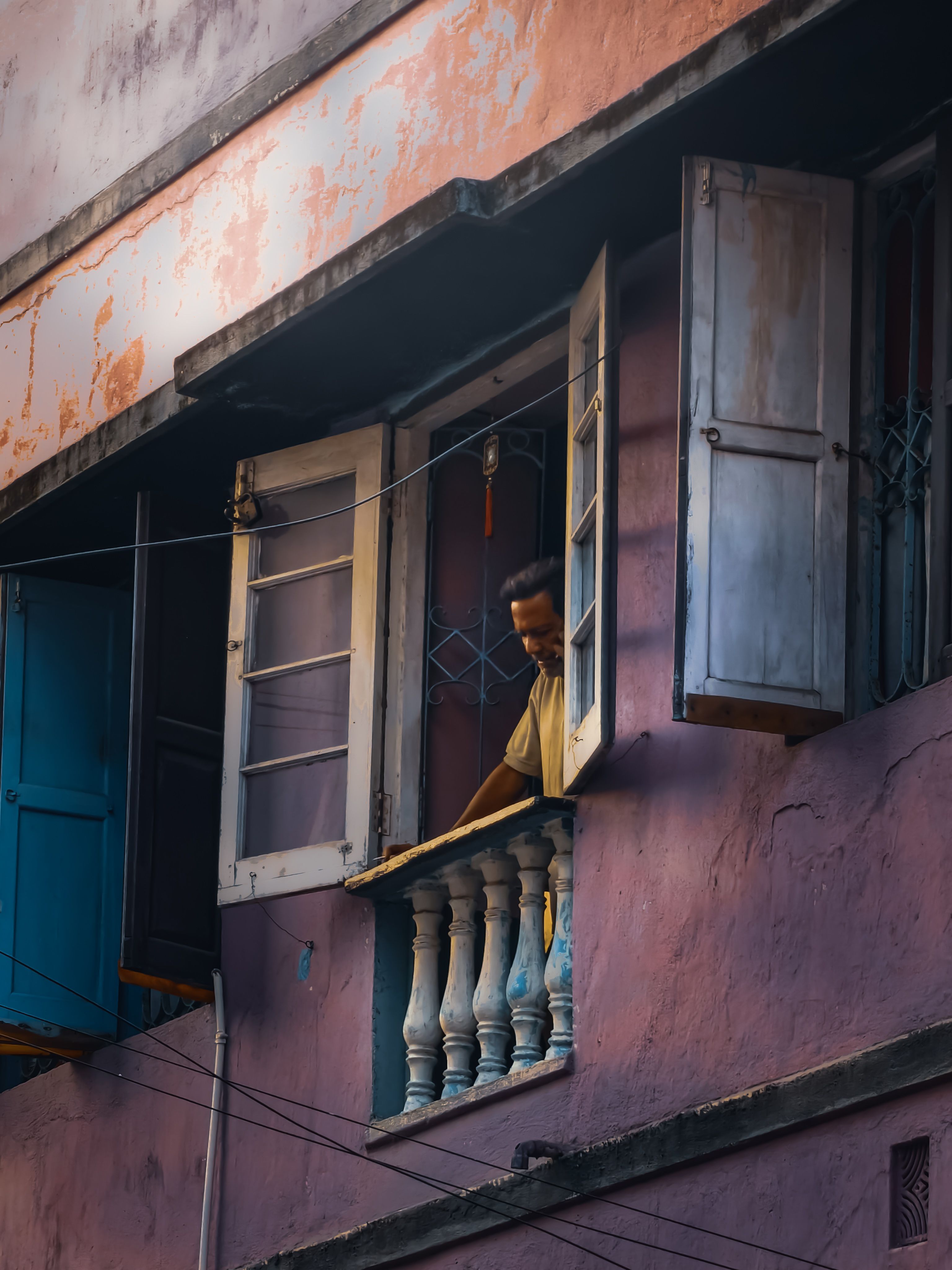 Man Looking Out of Open Window in Urban Scene · Free Stock Photo