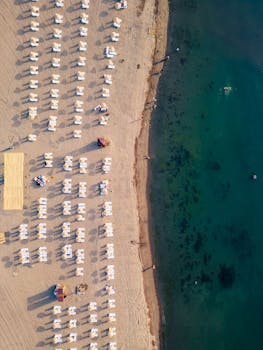 Discover the serene sandy beach at Ordu, Türkiye, captured from above with pristine chairs and azure waters.
