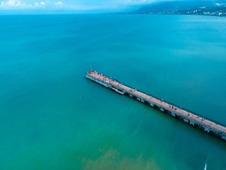 Stunning aerial view of Ünye Pier extending into the Black Sea under a vibrant sky.