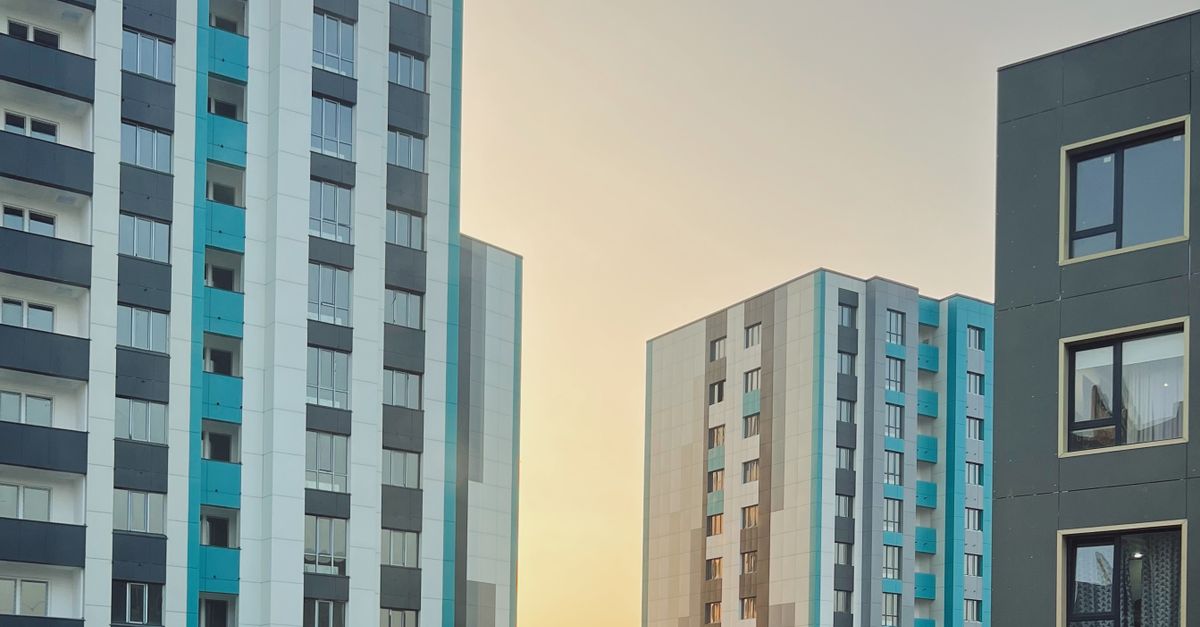 View of modern high-rise apartment buildings in Almaty, Kazakhstan, during sunset.