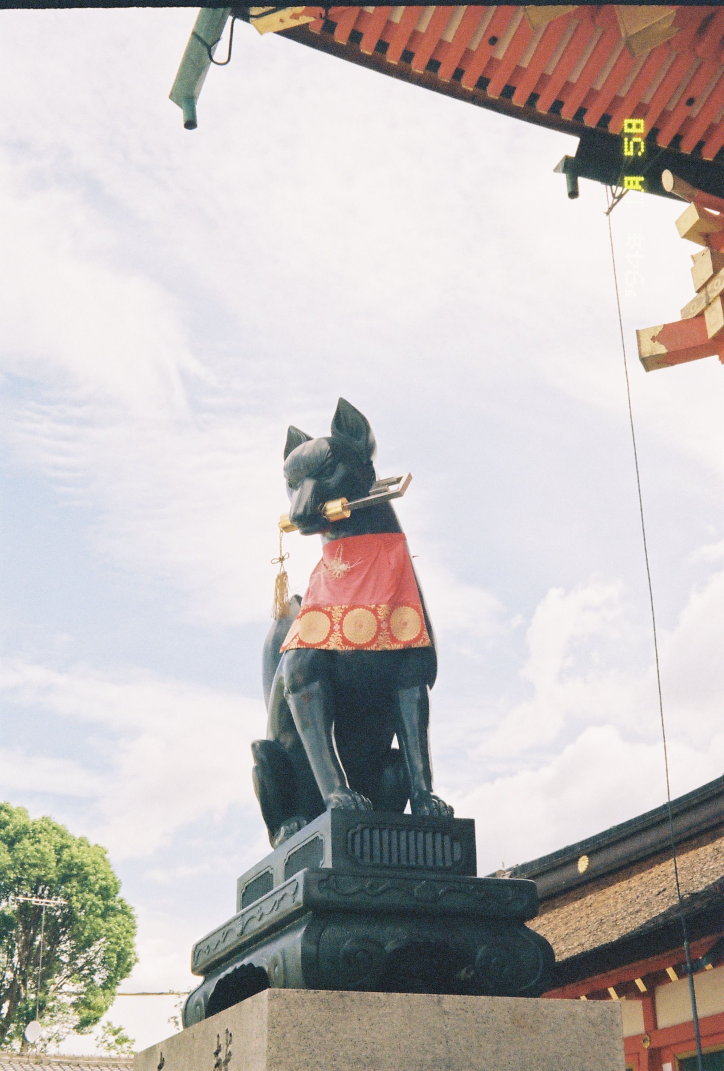 Statue of a fox with bib at Fushimi Inari Taisha in Kyoto, Japan.