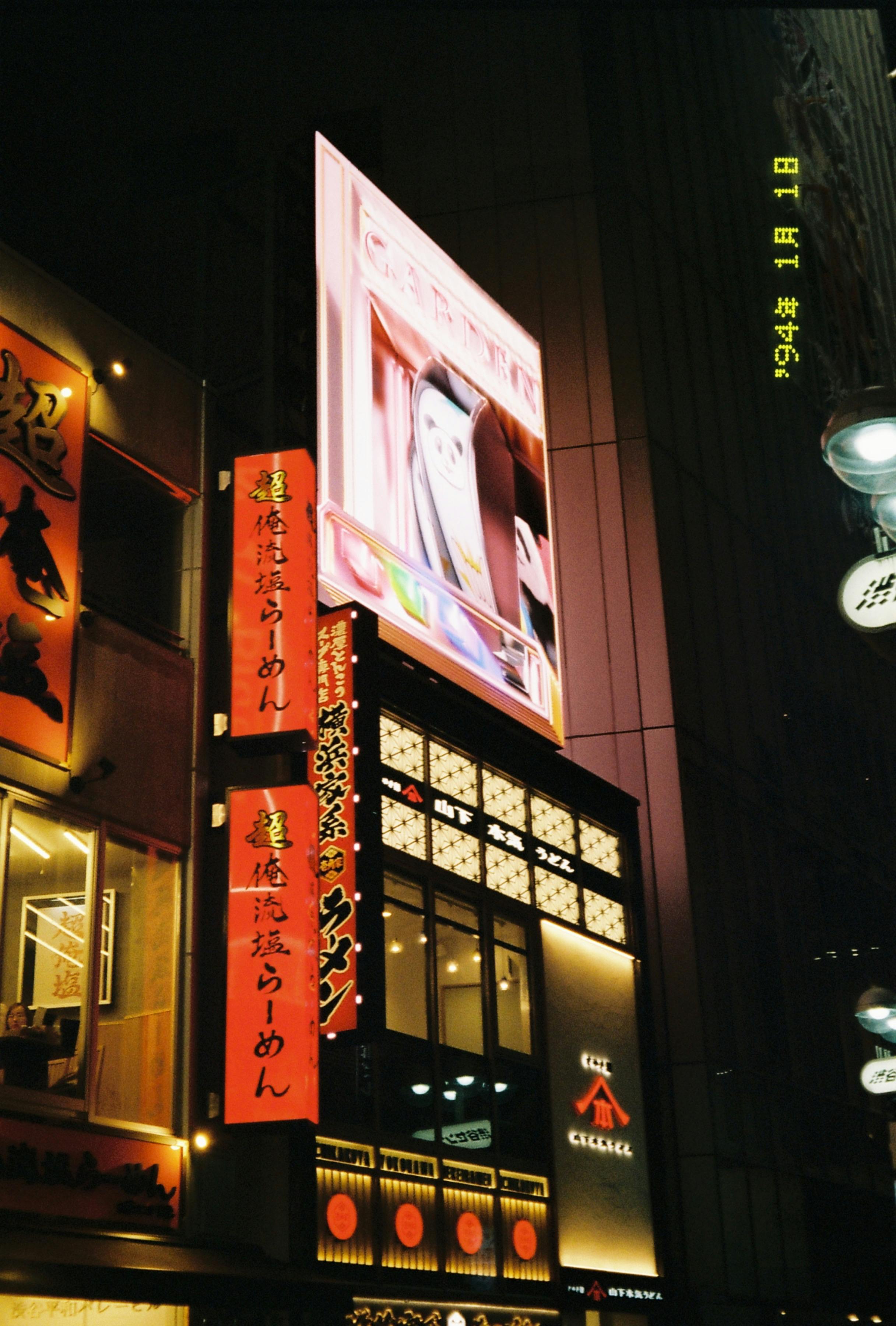 Gratuit Des néons lumineux et une vie nocturne animée dans une rue d'une ville japonaise Photos