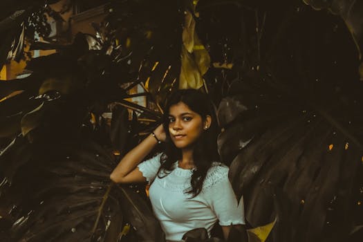 一位年轻女子在郁郁葱葱的热带树叶间自信摆姿，唤起一片宁静心境