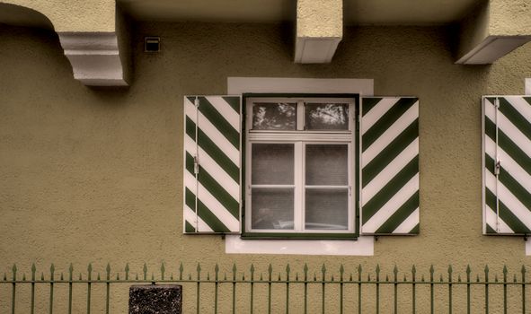 Classic green and white striped window shutters on a residential building in Regensburg.
