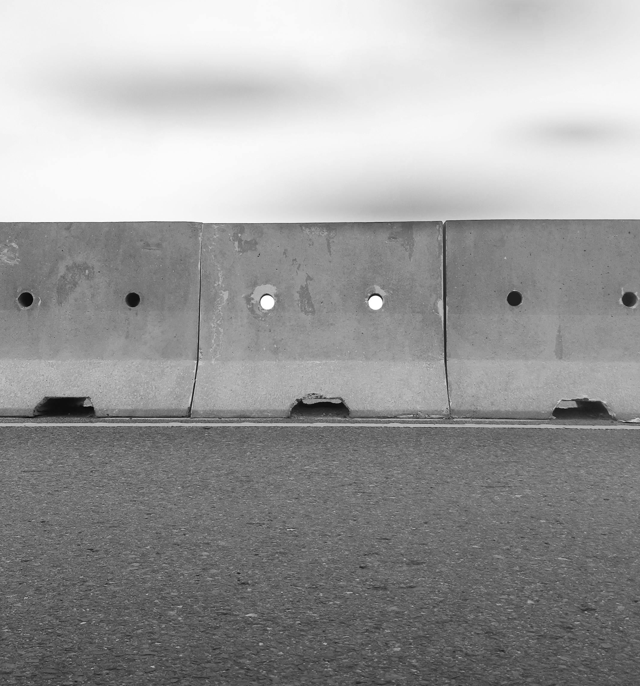 Gratis Svart-hvitt-bilde av betongbarrierer på en tom gate, som gir et urbant preg. Arkivbilde