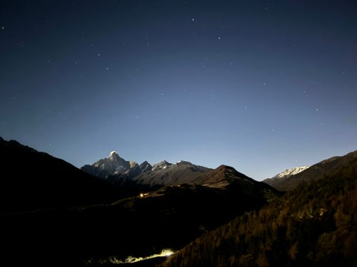 Free A breathtaking view of a star-studded night sky above a tranquil mountain range. Stock Photo