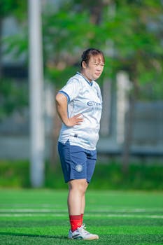 Asian female soccer player standing on field in Hanoi, Vietnam.