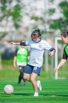 A young woman skillfully plays soccer on a sunny day in Hà Nội, Vietnam.