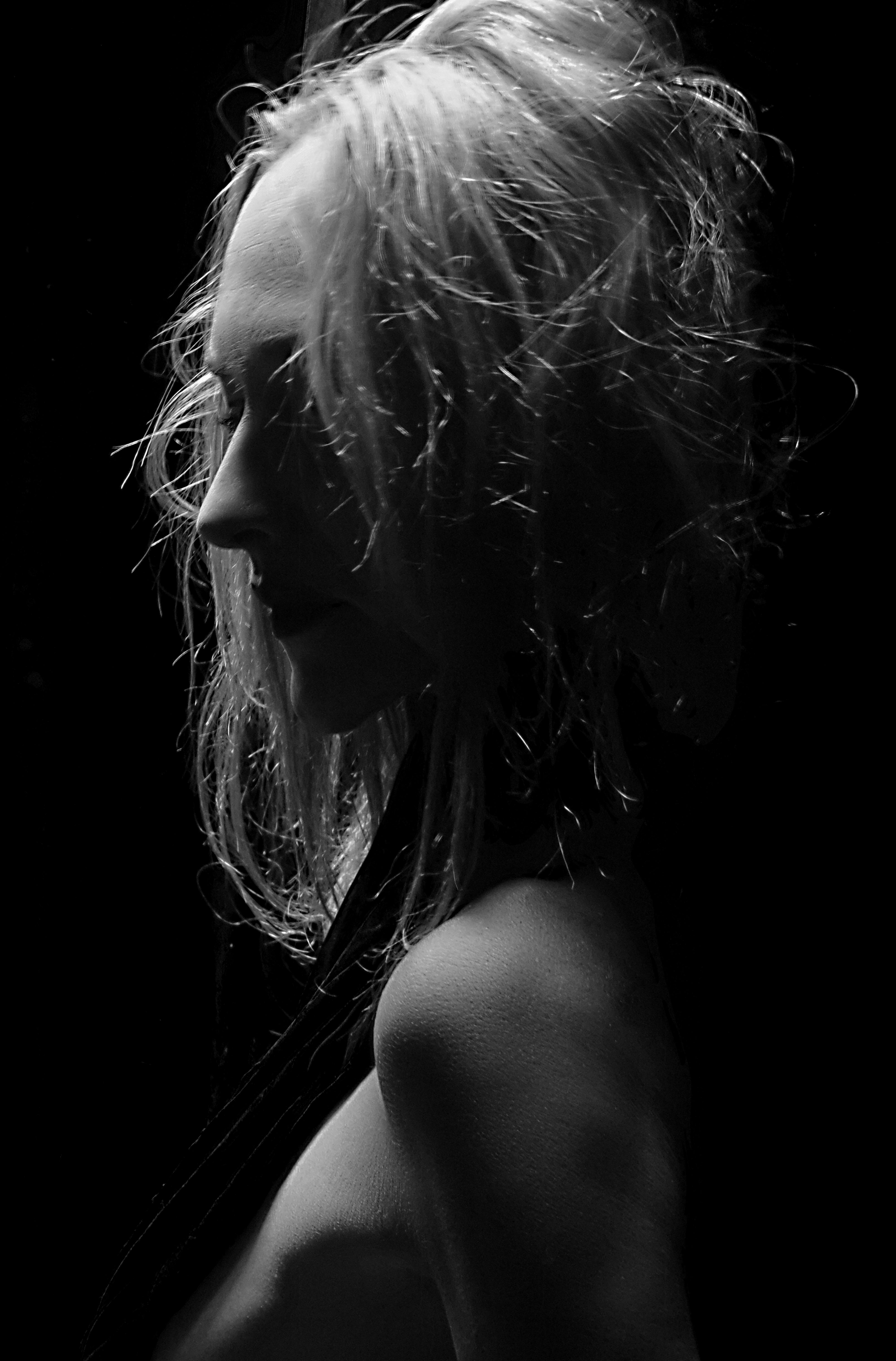 Dramatic black and white portrait of a woman in artistic lighting.