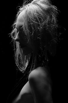 Dramatic black and white portrait of a woman in artistic lighting.
