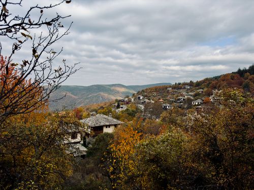 Free Picturesque autumn view of a traditional village in the Bulgarian mountains, surrounded by vibrant foliage. Stock Photo