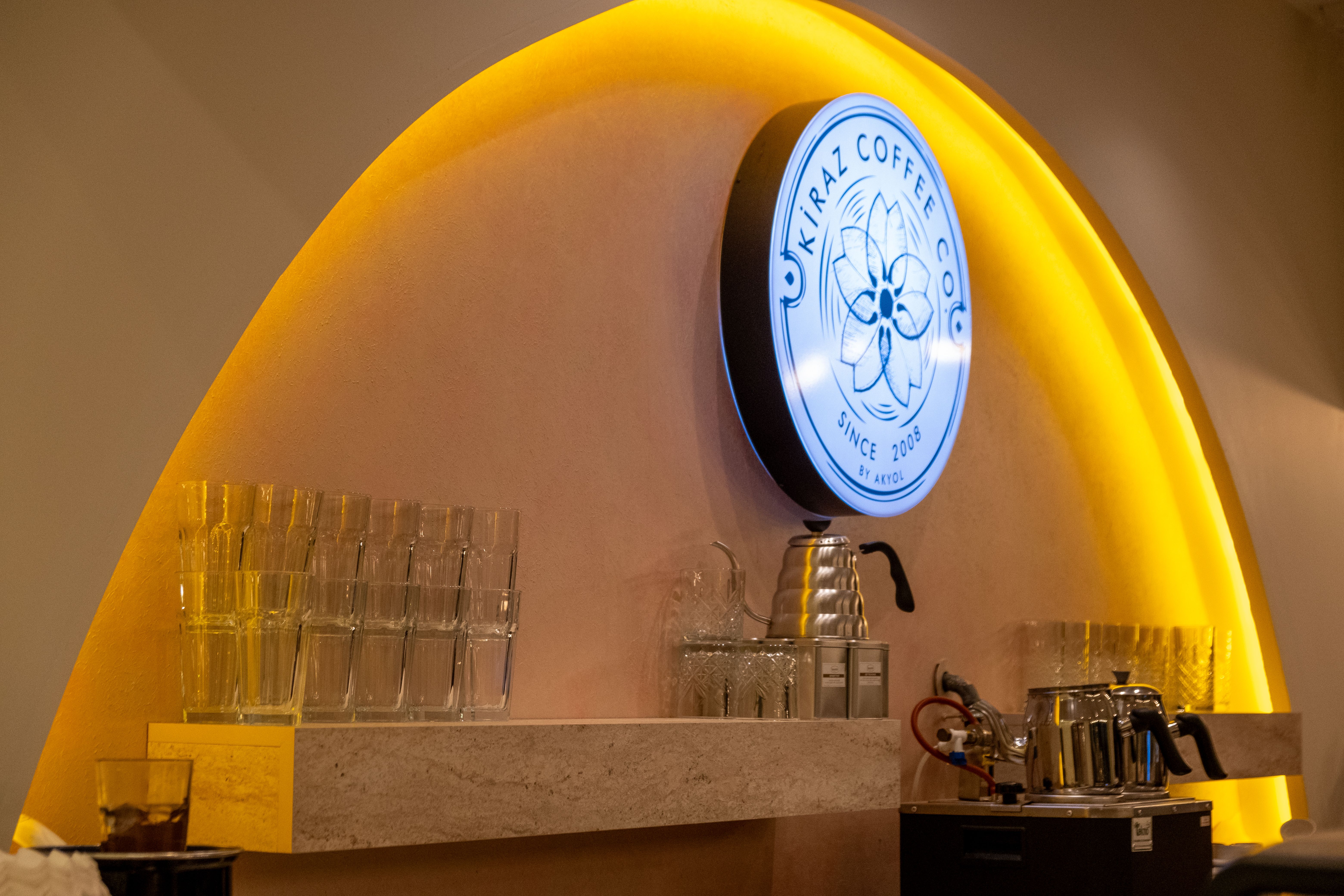 Stylish coffee shop interior featuring bar equipment and decorative lighting.