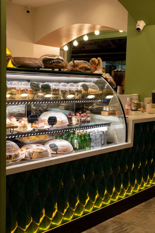 Free Inviting cafe interior featuring a pastry and beverage display counter. Stock Photo